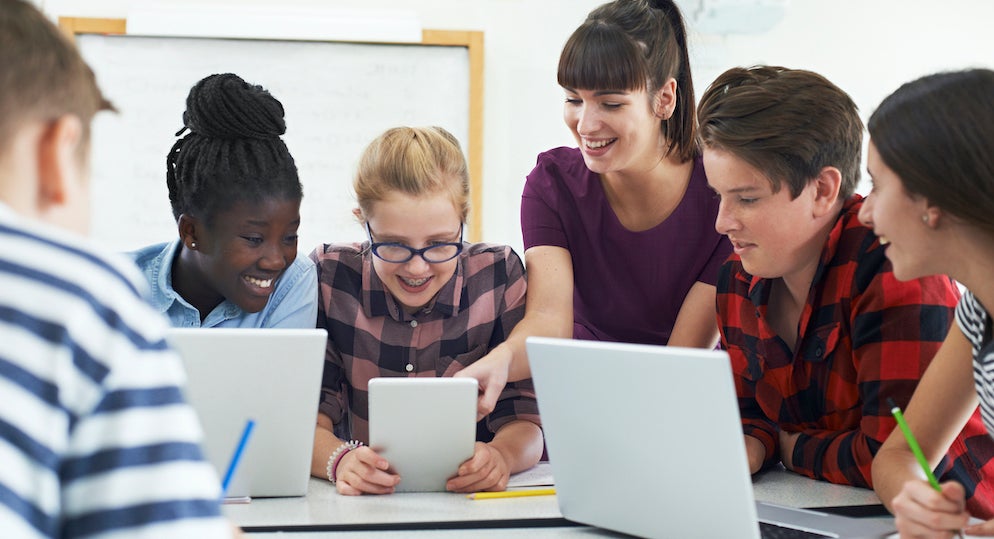 Teacher and students using laptops