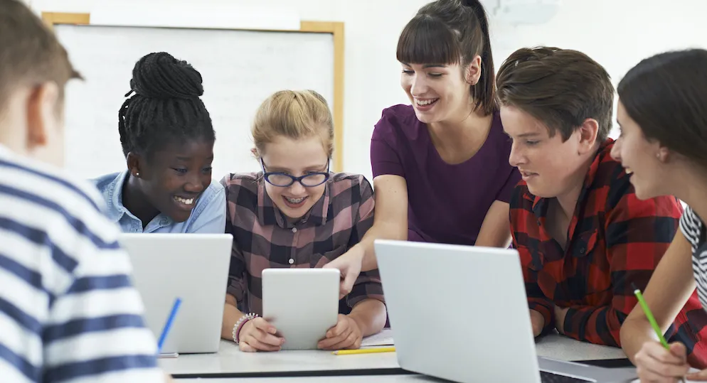 Teacher and students using laptops