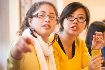 Two students point and discuss a project