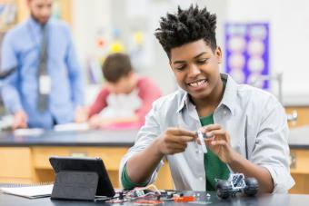 young black male smiles while doing a stem activity